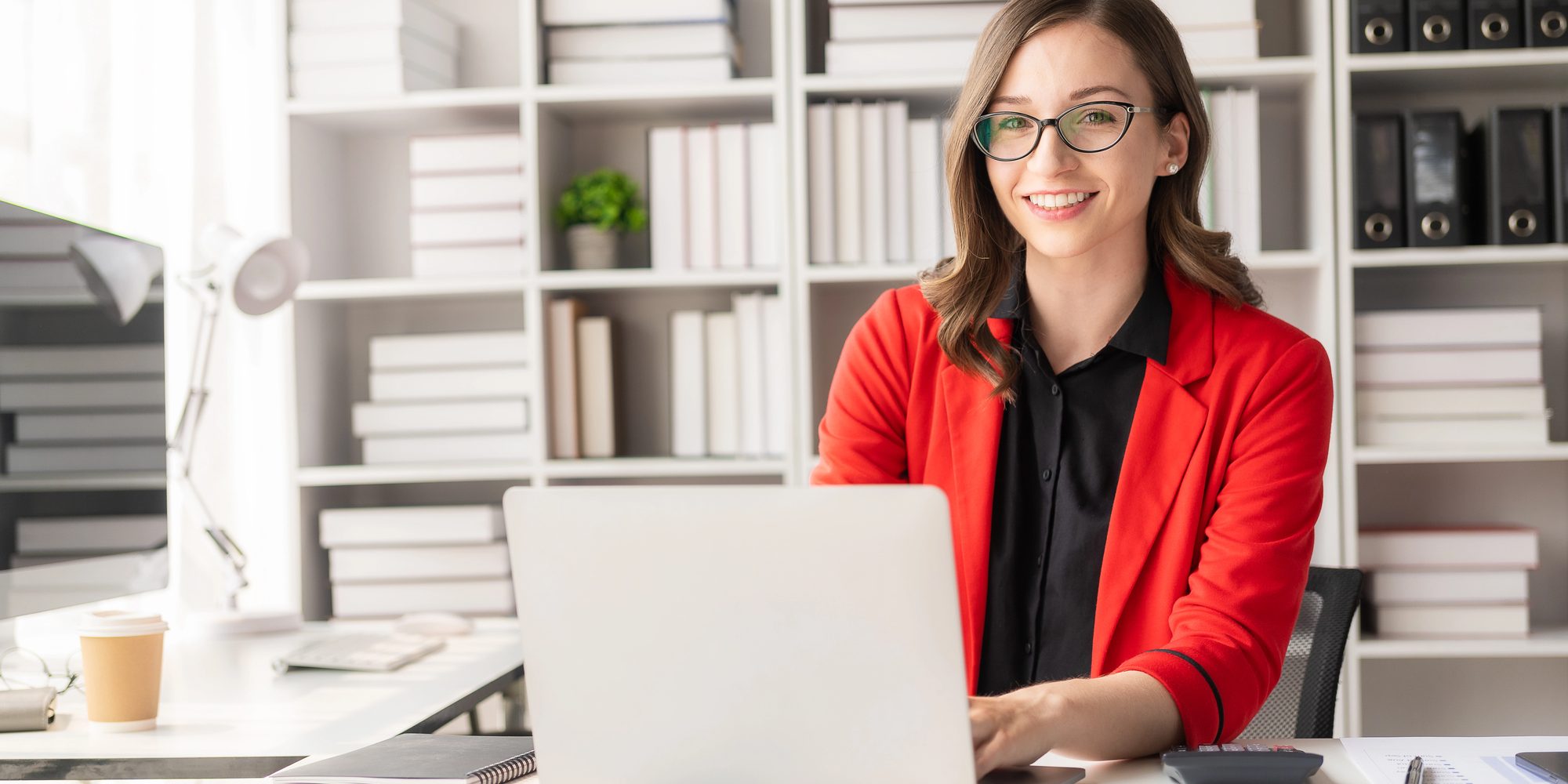 woman on a computer Smiling professional working on a laptop for New York No-Fault Collections